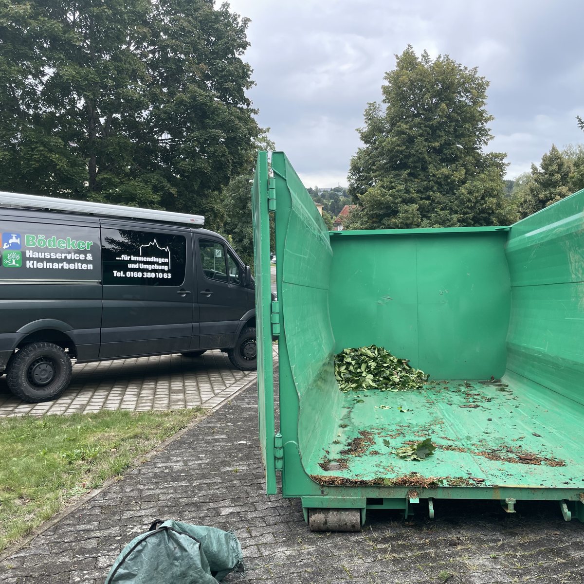 Hausmeisterservice Tuttlingen: Einsatzfahrzeug mit Container beim Grünschnitt-Abtransport